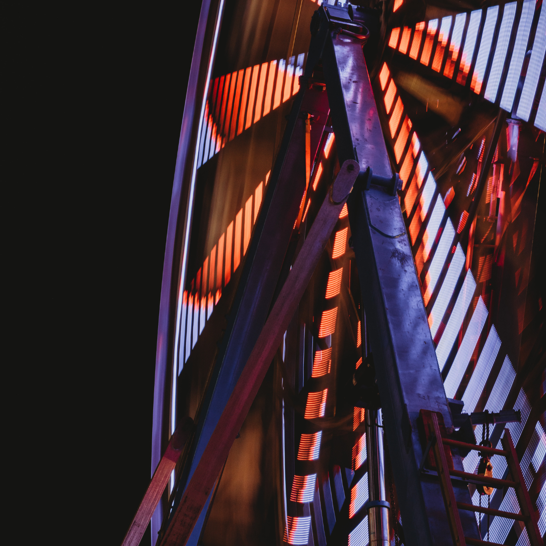 Colorful red and blue LED lights illuminate a Ferris wheel at night on the midway of the Wyoming State Fair.