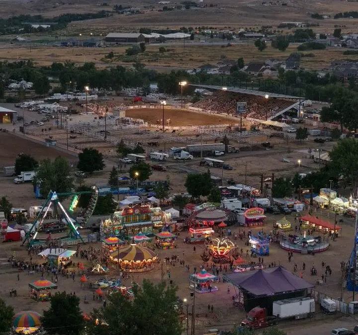 Overhead view of the carnival midway with rides, games, and crowds at the Wyoming State Fair.